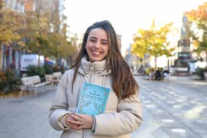 Foto de Alba Gil autor sosteniendo su libro "El viaje de las Pléyades"